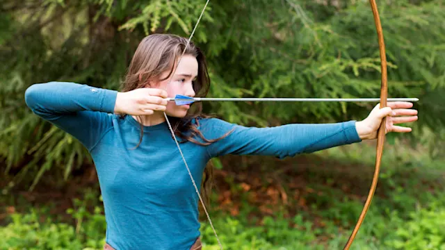 Summer camper drawing a bow
